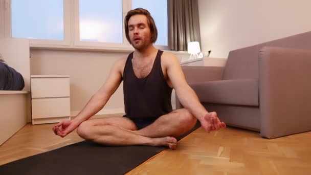 Ciddi bir genç adam evde meditasyon yapıyor. Farkındalık ve refah kavramı - Video, Çekim