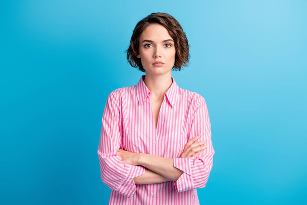 Fotoporträt von welligen ernst charmante Geschäftsfrau gekleidet formale rosa Hemd Arme gekreuzt isoliert blaue Farbe Hintergrund - Foto, Bild