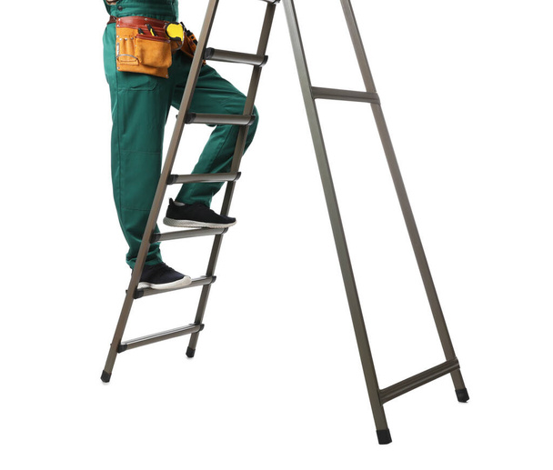 Professional constructor climbing ladder on white background, closeup - Fotó, kép