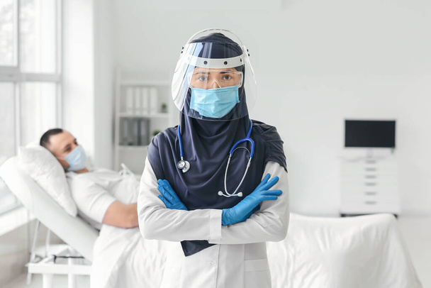 Muotokuva naispuolinen muslimi lääkäri yllään suojaava univormu klinikalla - Valokuva, kuva