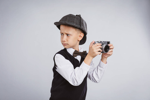 Cute little detective with vintage camera on grey background - Fotó, kép