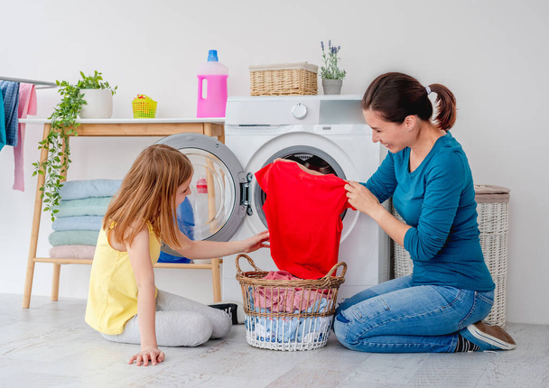 Mother with daughter near washing machine - Fotoğraf, Görsel