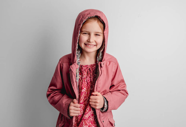 Little girl in pink jacket standing indoors - Zdjęcie, obraz