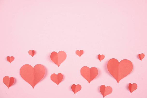 Heart shaped paper sticked on pink background. Emblem of love for happy women, beloved mother, birthday cards and valentine greeting designs. Valentine's day backgrounds. Templates to convey our love. - 写真・画像