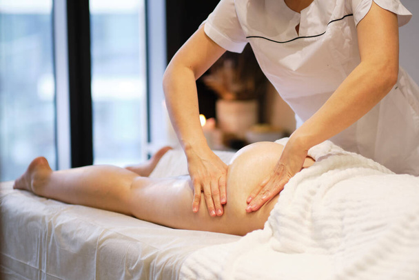 masajista hace anticelulitis masaje mujer joven en el salón de spa. Concepto de cuidado corporal. Tratamiento especial contra la celulitis. - Foto, imagen