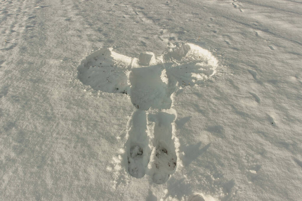 Сніговий ангел на свіжому снігу. Слід людського дорослого тіла в зимовому пейзажі. Друк простору для копіювання тіла. Сцена злочину в природі, форма тіла снігової текстури.
. - Фото, зображення
