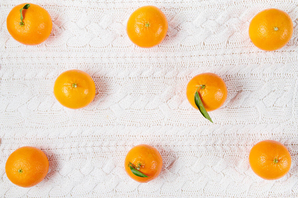 winter flat lay with mandarins on white knitted background. - Foto, Imagem