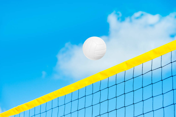 Білий пляжний волейбольний м'яч над жовтим сіткою. Спортивний фон з копіювальним простором для тексту та реклами
. - Фото, зображення