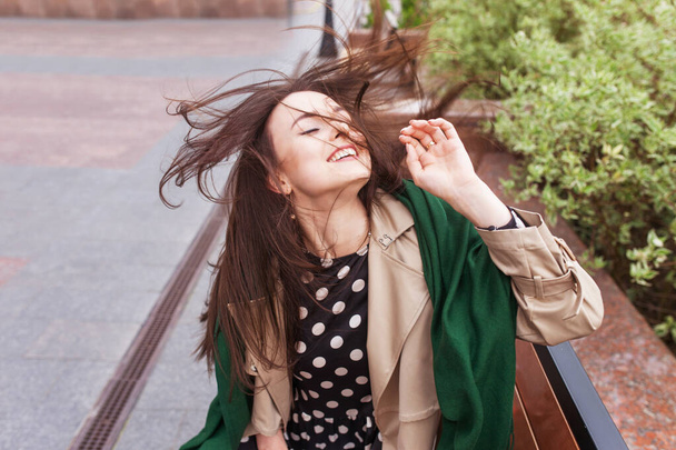 Smiling beautiful girl in the city. Wind developing long hair of happy young woman. Copy space - Foto, Bild