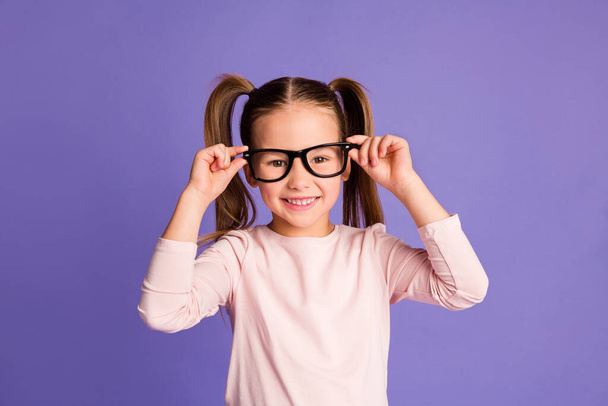 Photo of cheerful happy little girl wear hold glasses sweatshirt isolated on violet purple color background - Fotoğraf, Görsel