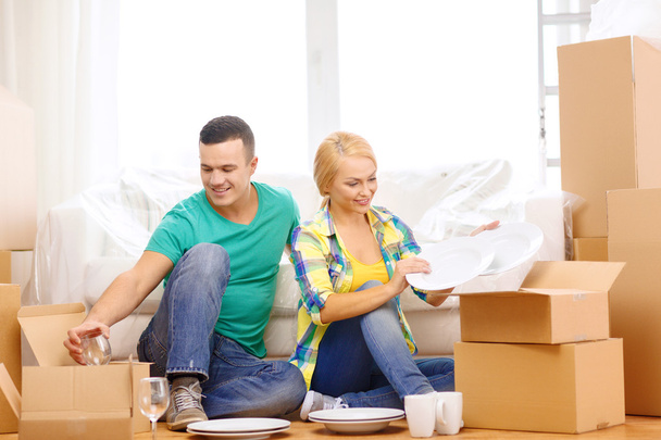 Smiling couple unpaking boxes with kitchenware - Fotoğraf, Görsel
