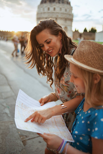 sonriente madre moderna y niño con mapa en piazza dei miracoli en Pisa, Italia. - Foto, imagen