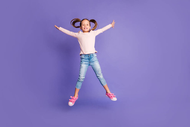 Full size photo of pretty cheerful little girl jump up star shape wear jeans isolated on violet color background - Foto, Bild