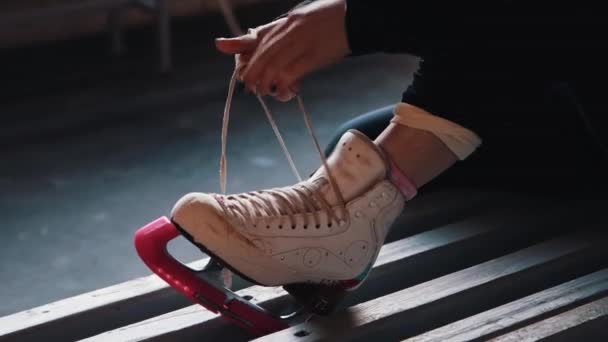 Genç bir kadın ayakkabı bağcıklarını beyaz patenlere bağlıyor. - Video, Çekim