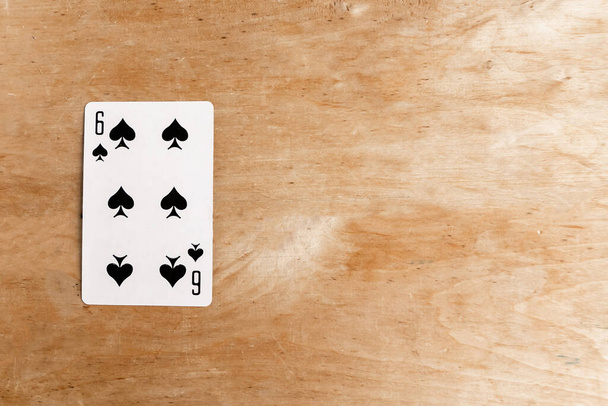 Six of Spades playing card, wooden background, copy space - Foto, Imagen