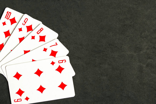 Poker straight flush playing card, top view, black background - Foto, imagen