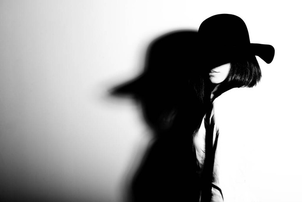 Mysterious fashion young woman in black hat and white shirt, copy space where can the advertising message be written, black and white - 写真・画像
