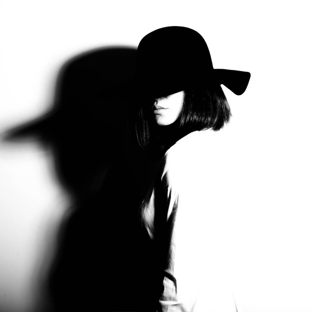 Mysterious fashion young woman in black hat and white shirt, copy space where can the advertising message be written, black and white - Photo, Image