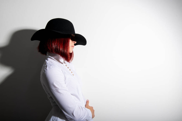 Mysterious fashion young woman in black hat and white shirt, copy space where can the advertising message be written - Photo, Image