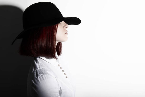 Salaperäinen muoti nuori nainen musta hattu ja valkoinen paita, kopioi tilaa, jossa mainos viesti voidaan kirjoittaa - Valokuva, kuva