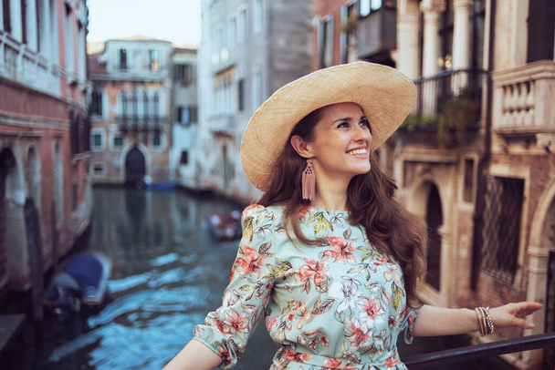 happy elegant solo tourist woman in floral dress with hat having excursion in Venice, Italy. - Φωτογραφία, εικόνα