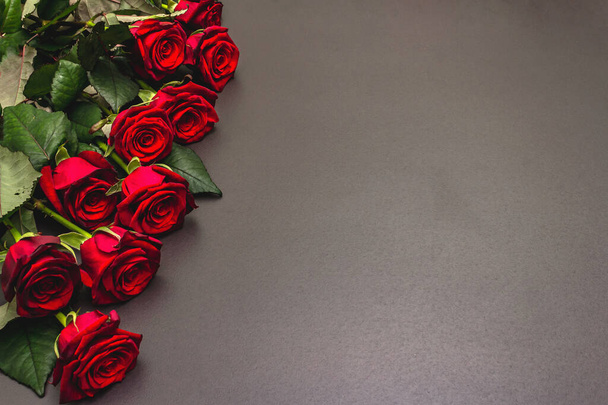 Bukett frischer weinroter Rosen auf schwarzem Steinbeton-Hintergrund. Duftende rote Blumen, Geschenkkonzept für Valentinstag, Hochzeit oder Geburtstag - Foto, Bild
