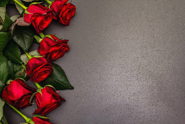 Buquê de rosas de borgonha frescas em um fundo de concreto de pedra preta. Flores vermelhas perfumadas, conceito de presente para o Dia dos Namorados, casamento ou aniversário - Foto, Imagem