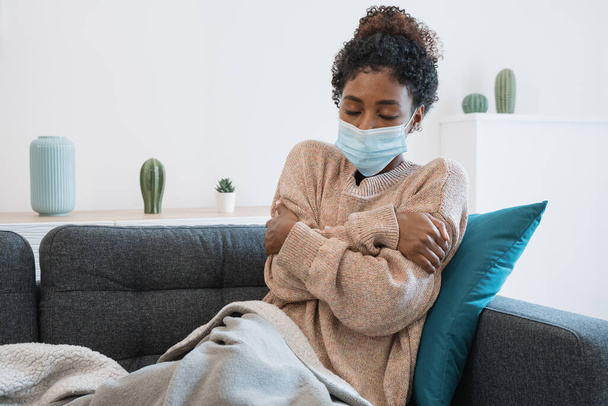 Μαύρο κορίτσι που έχει γρίπη, αισθάνεται άσχημα και βρίσκεται στον καναπέ - Φωτογραφία, εικόνα