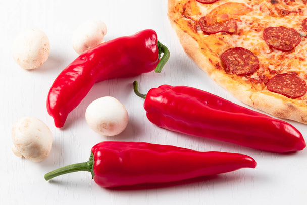 свіжа ароматна гаряча італійська піца пепероні з сиром моцарелла, червоним перцем та грибами на білому дерев'яному столі
 - Фото, зображення