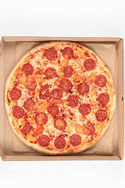 frische aromatische italienische Pfefferoni-Pizza mit Mozzarella in einem Karton - Foto, Bild