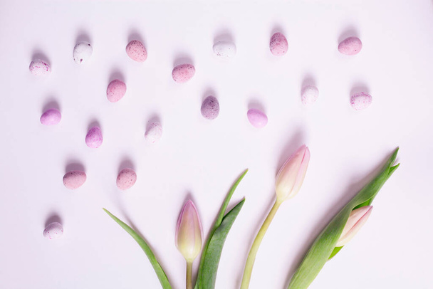Růžové pastelové Velikonoce s jemnými tulipány, sladkými pusinkami a čokoládovými vejci potaženými cukrem. Baby pink colors. - Fotografie, Obrázek