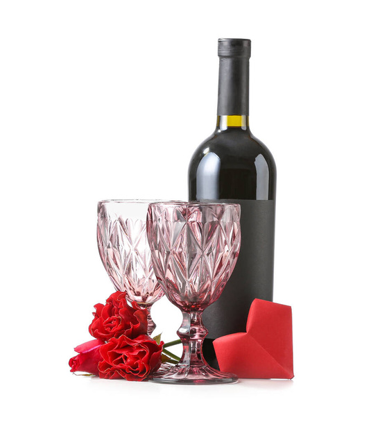 Bottle of wine with glasses and rose flowers on white background - 写真・画像