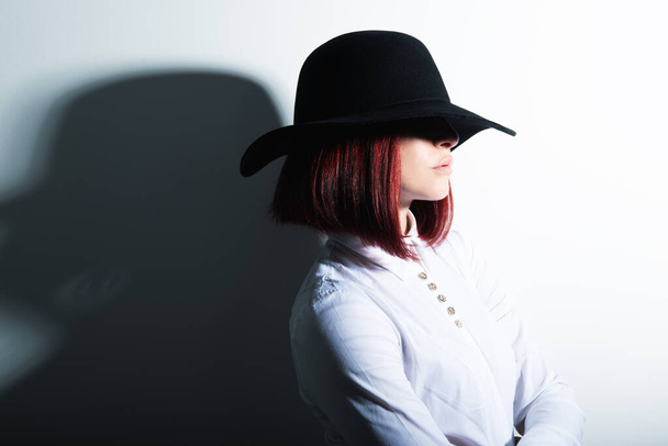 Mysterious fashion young woman in black hat and white shirt, copy space where can the advertising message be written - 写真・画像