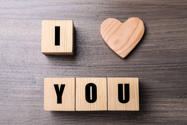 Phrase I love You made of decorative heart and cubes on wooden background, flat lay - Photo, Image