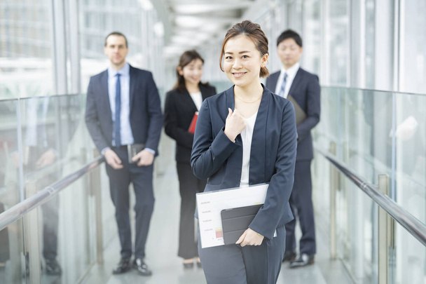 Sorridente asiatico business donna standing e suo business team - Foto, immagini