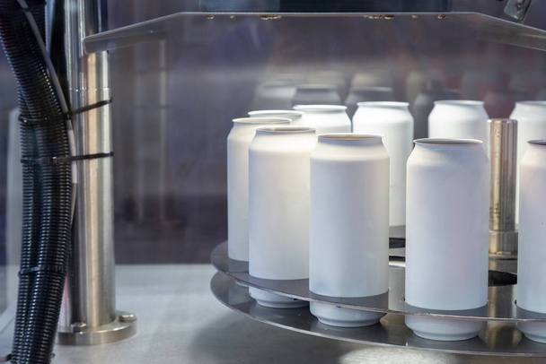 порожні нові білі алюмінієві банки для процесу напоїв скануються і переміщуються на заводській лінії на конвеєрній стрічці машини при виробництві напоїв. бізнес концепція харчової промисловості та напоїв
. - Фото, зображення