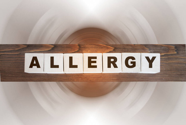palabra de alergia en cubos de madera en mesa de madera oscura. Concepto sanitario - Foto, Imagen