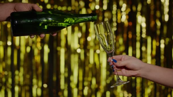 Champán bebida alcohólica se vierte de la botella en el vidrio de beber fondo de oro en cámara lenta - Metraje, vídeo