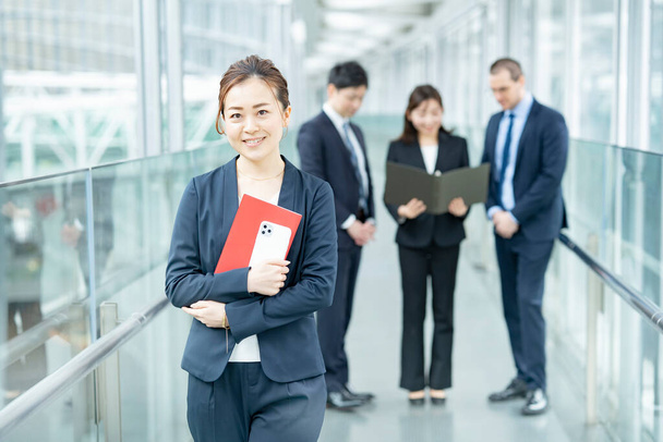 笑顔のアジア系のビジネス女性と彼女のビジネスチーム - 写真・画像