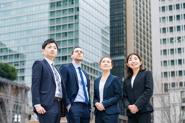 Μια επιχειρηματική ομάδα τεσσάρων ανδρών και γυναικών με κοστούμια - Φωτογραφία, εικόνα
