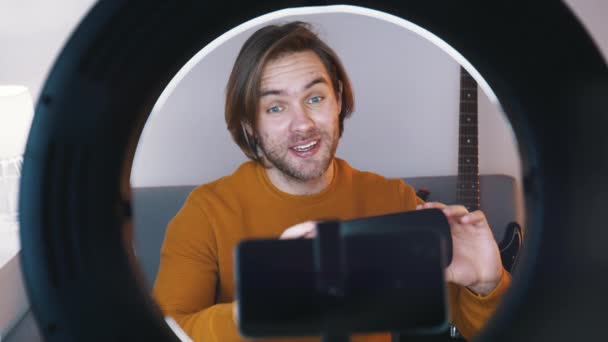 Jeune homme caucasien influenceur enregistrement vidéo sur son smartphone tout en tenant des lunettes vr - Séquence, vidéo
