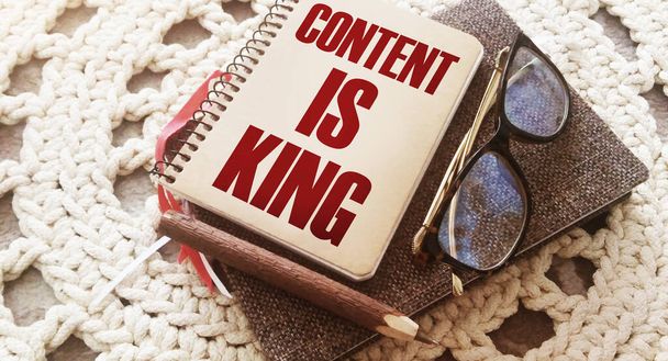 Omslag van het notitieboek met woorden Content Is King, bril en pen. Verhalen vertellen copywriting business en onderwijs concept. - Foto, afbeelding