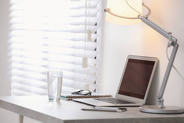 Modern workplace with laptop on grey table in office - Fotografie, Obrázek
