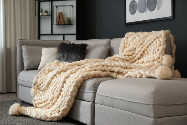 White knitted plaid on sofa in living room. Interior design - Fotoğraf, Görsel