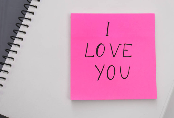 Memory sticker with phrase I Love You on notebook, top view. Valentine's Day celebration - Fotoğraf, Görsel