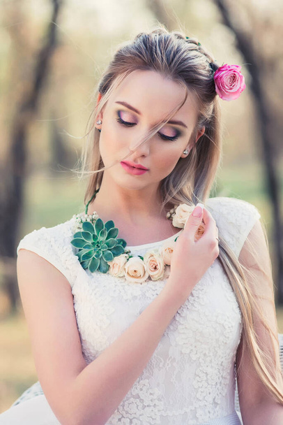 Spring beautiful woman outdoors portrait. Romantic sensual lady with flowers. Femininity and beauty concept - 写真・画像