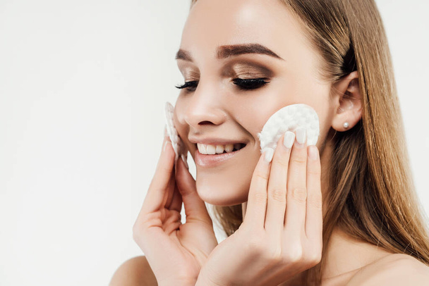 Close up of a woman's face in perfect condition. Freshness and naturalness. Woman holding cotton pads near her face. Concepts for advertising. - Фото, изображение