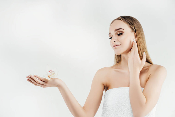 Portrait of a woman with perfect skin. Beautiful blonde spa girl showing blank copy space on palm with open hand for text. Offering goods. Gesture for advertising. Isolated on image. - Fotoğraf, Görsel
