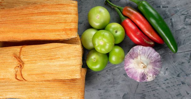 Mexican cuisine, meat tamales accompanied by garlic, chili and tomato - Foto, imagen