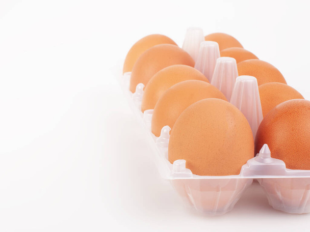 Νωπά αυγά κότας στο κουτί με τα αυγά στο λευκό φόντο - Φωτογραφία, εικόνα